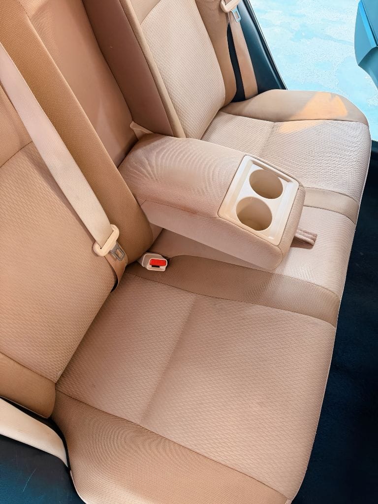 Freshly detailed tan rear bench seat with armrest cup holders — interior detail work by Brightworks Fort Worth