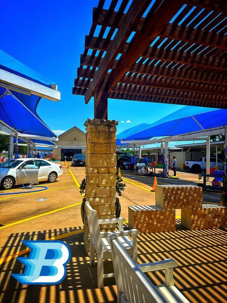 Brightworks Granbury — covered detail bays with pergola seating area and cars being serviced