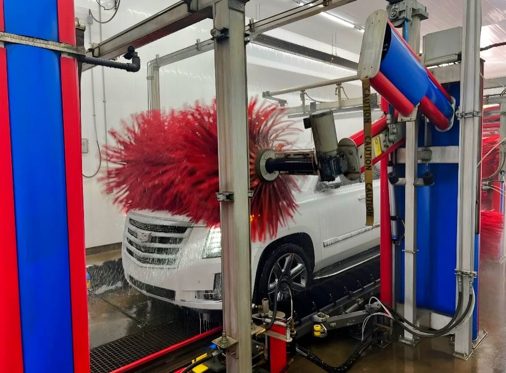 Brightworks Granbury exterior wash — white Cadillac Escalade rolling through the exterior wash with side and top brushes