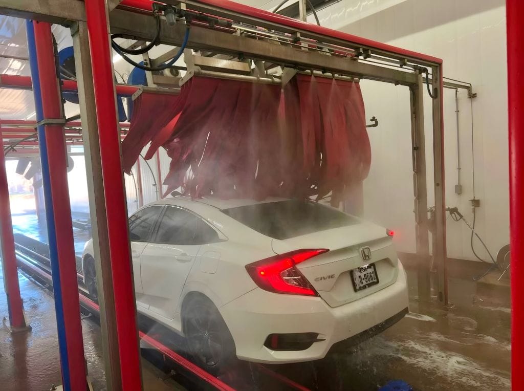 Brightworks Granbury exterior wash — white Honda Civic exiting the rinse arch at the end of the exterior wash